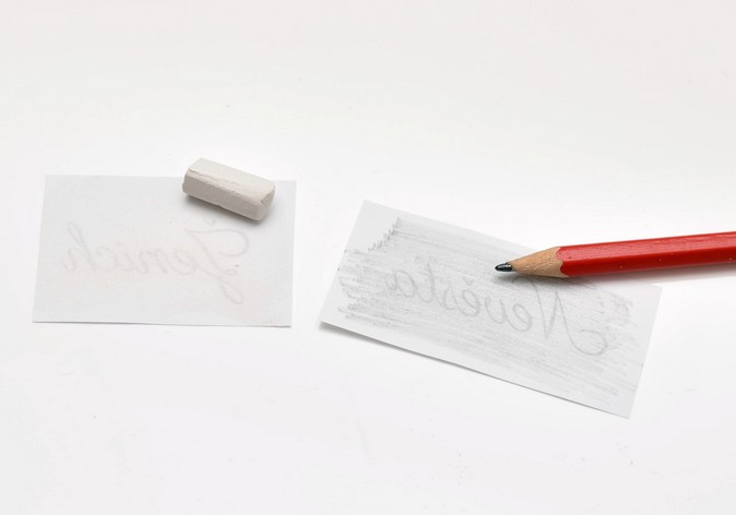 Papírky s texty přetřené křídou a tužkou - bílá křída a tužka
