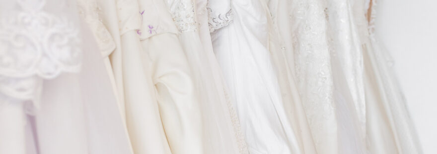 svatební šaty pověšené na ramínku v řadě